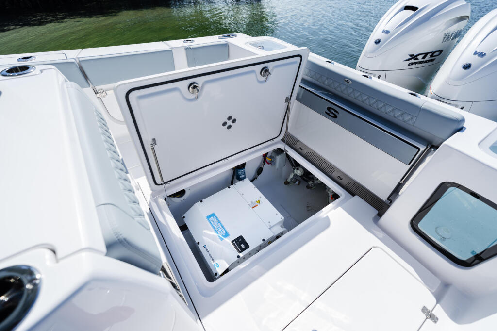 Open livewell with cooler storage compartment and electronic controls on fishing boat deck