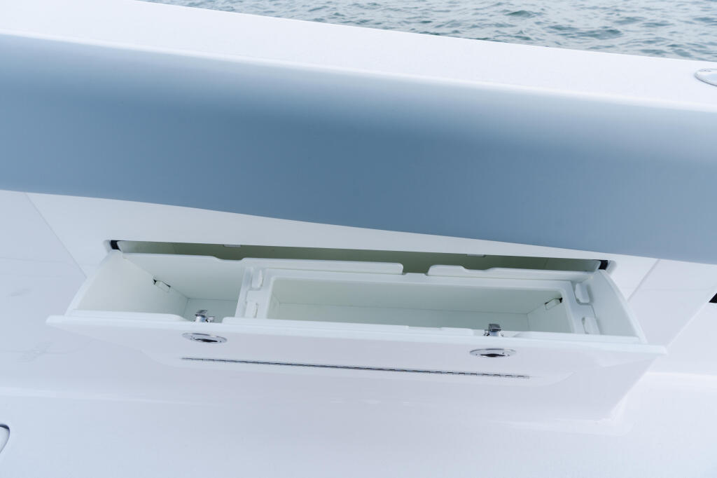 Open livewell compartment with green lid on white fiberglass boat hull