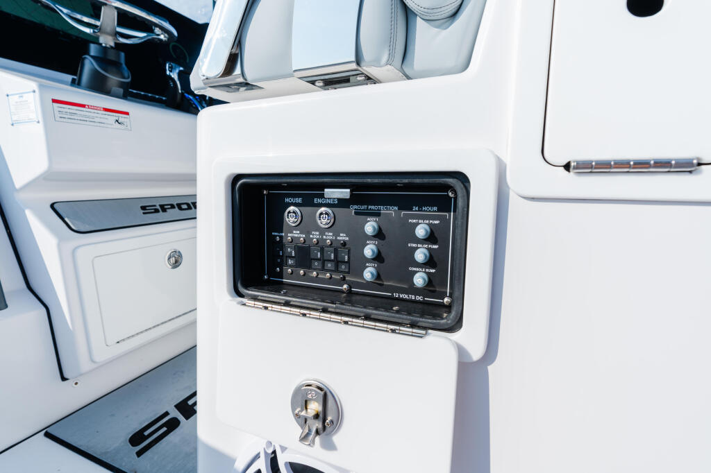 Control panel with switches for house and engine systems, circuit protection, and 12-volt DC power distribution mounted on cabin wall