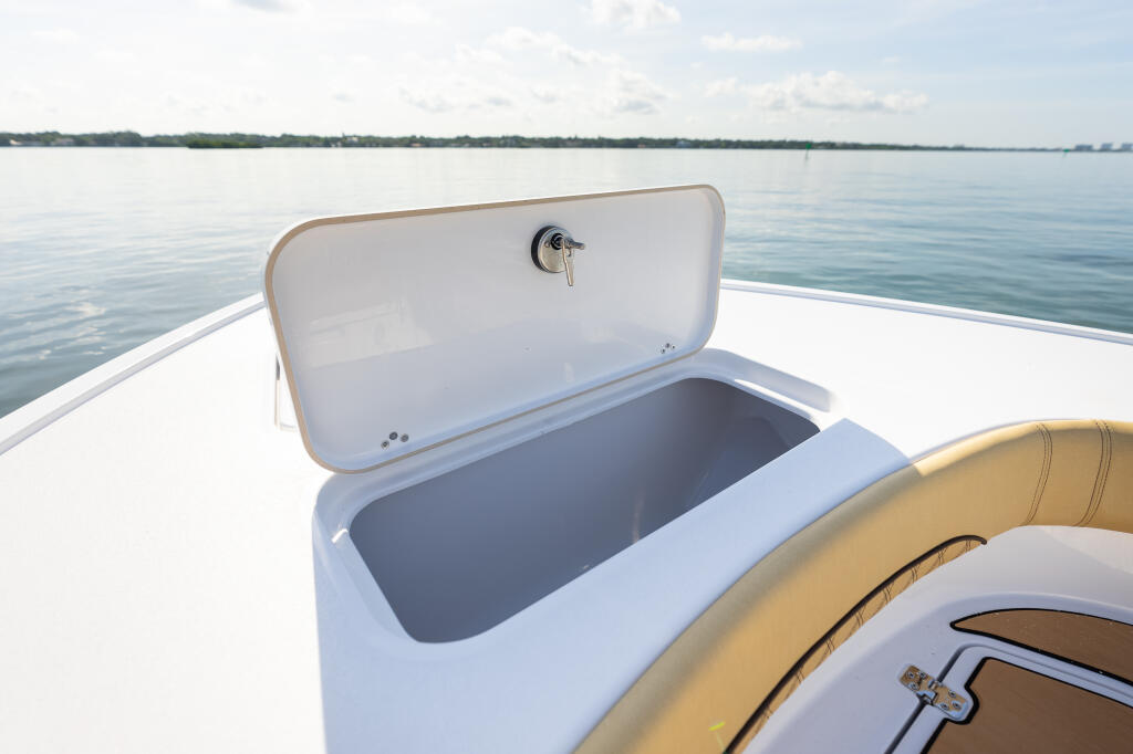Open 36-gallon bow fish box with chrome latch on white fiberglass boat deck