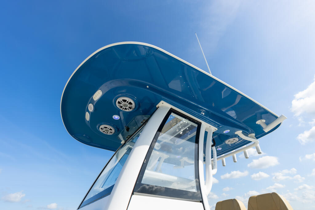 Overhead view of boat hard-top showing twin engines, lights, and windshield against blue sky
