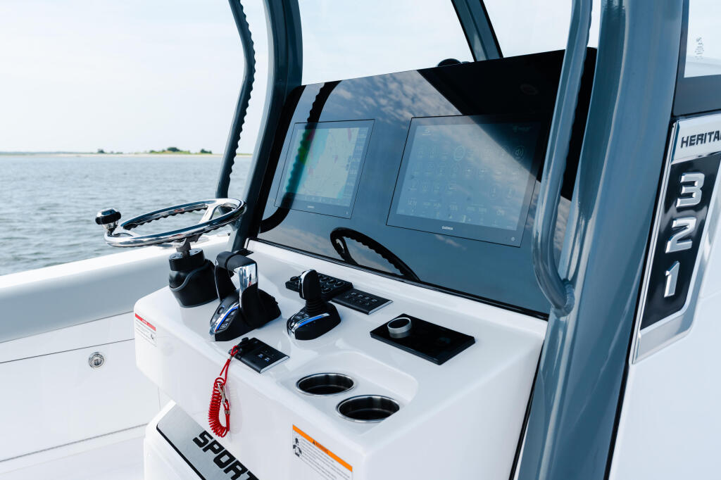 Helm station with twin screens, control panel, and steering wheel on Heritage 321 center console boat