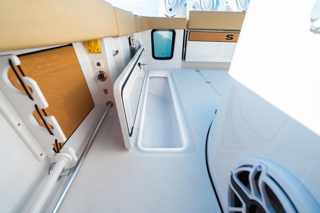 Open-style boat cockpit with livewell, helm window, tan canopy, and storage features viewed from above