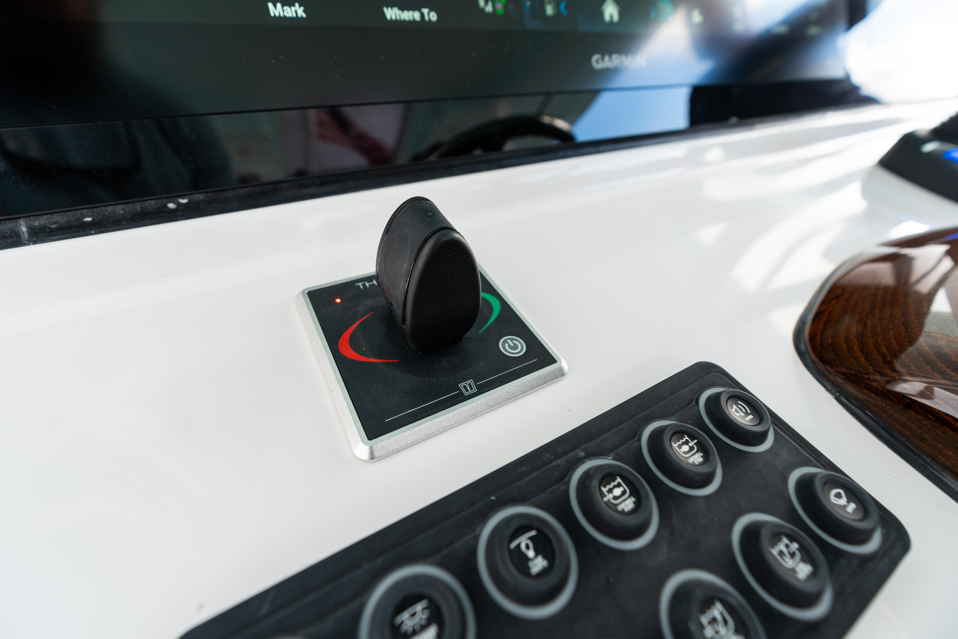 Boat helm console showing joystick control and button panel with digital display screen above