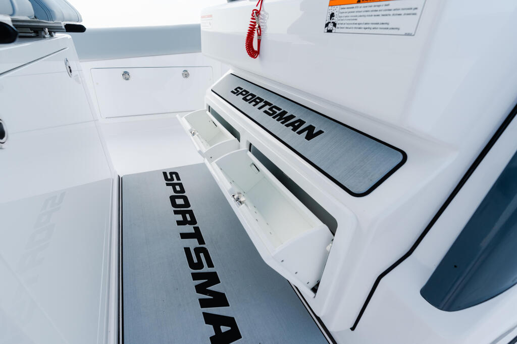 Sportsman branded storage compartments on the side of a white recreational fishing boat