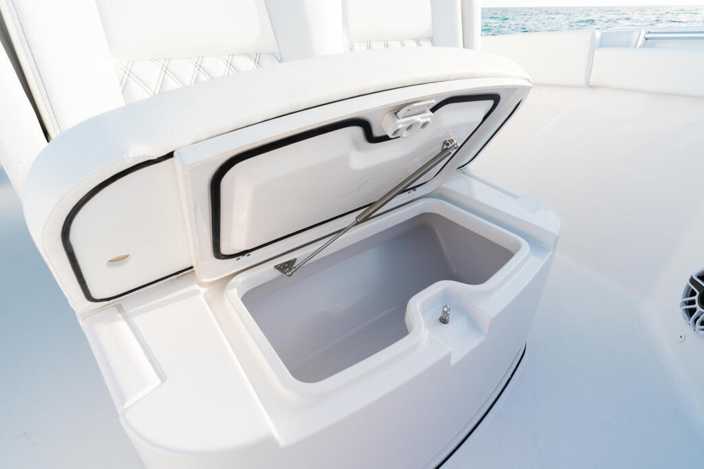 Open livewell with clean white interior storage compartment on fishing boat deck