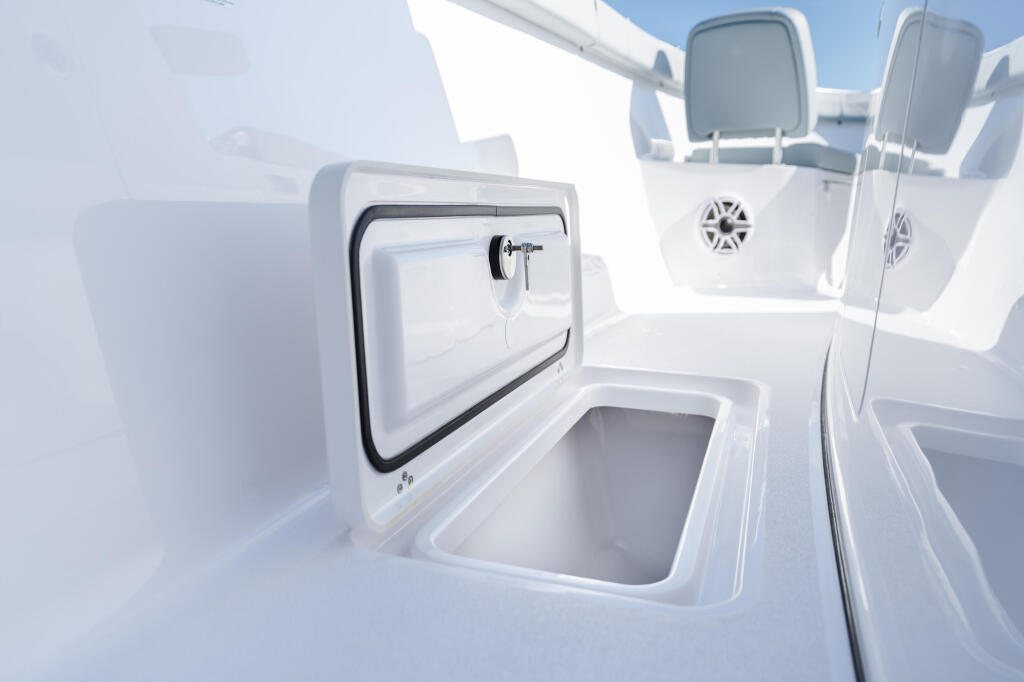 Open fish box and storage compartment with hinged livewell door on white boat console