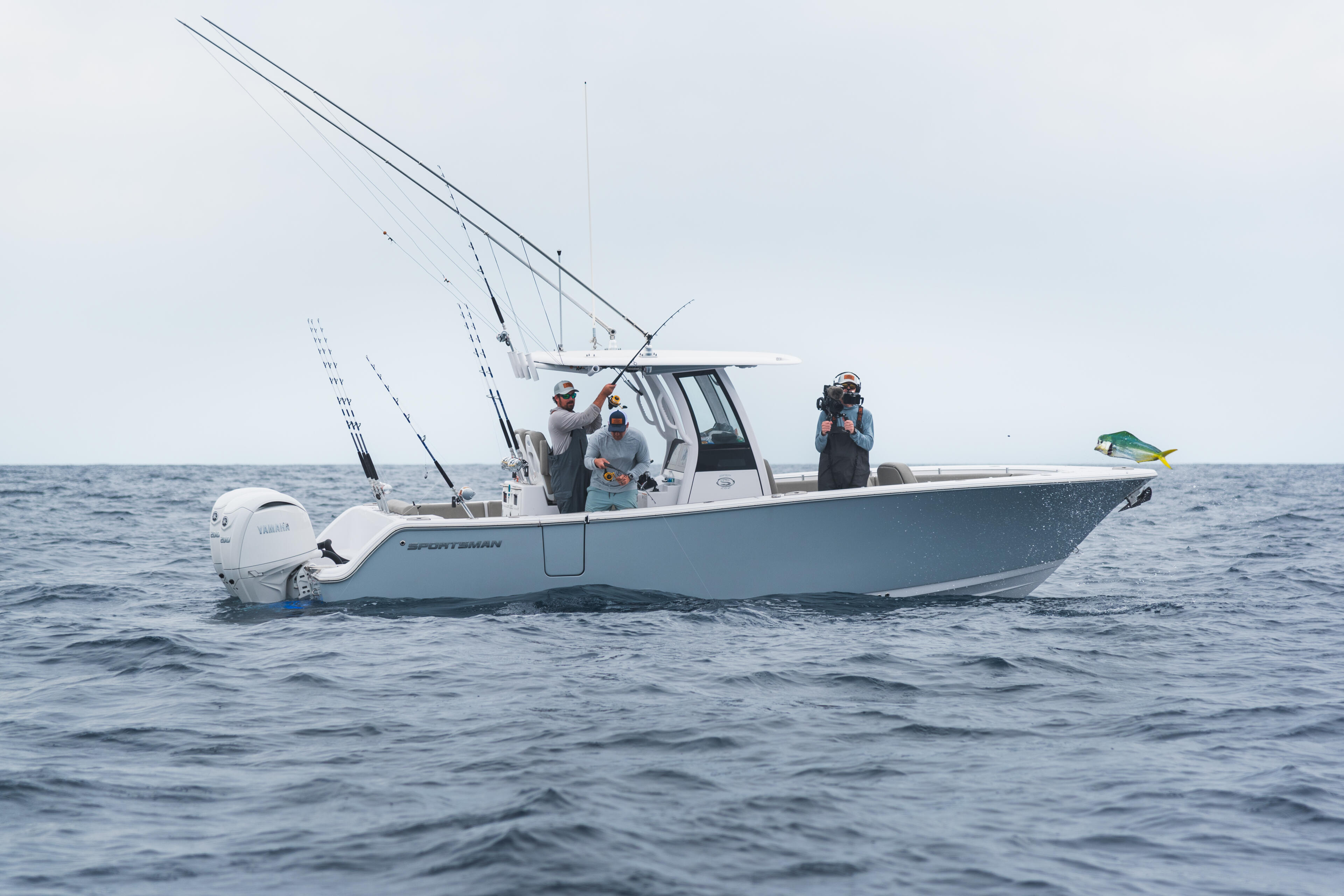 Anglers on a center console fishing boat in offshore waters with multiple fishing rods mounted on the gunwales