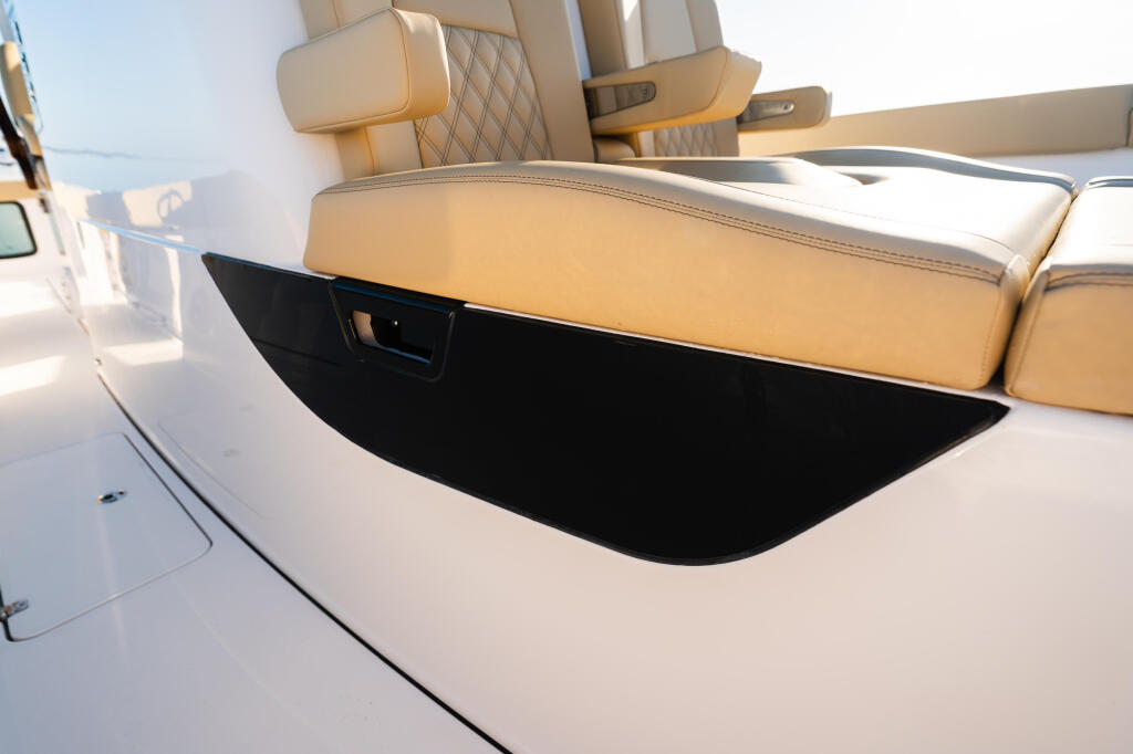 Tan upholstered seating with open storage compartment on boat deck