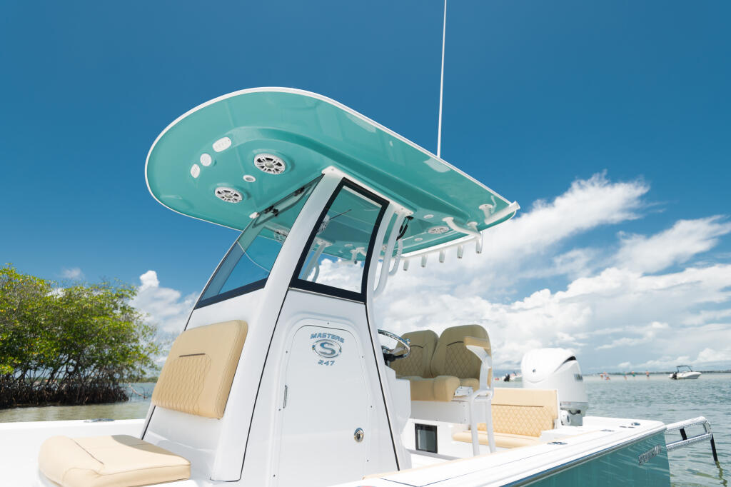 Masters 247 bay boat with turquoise hard-top, white cabin, cream seating, and mangrove shoreline in background