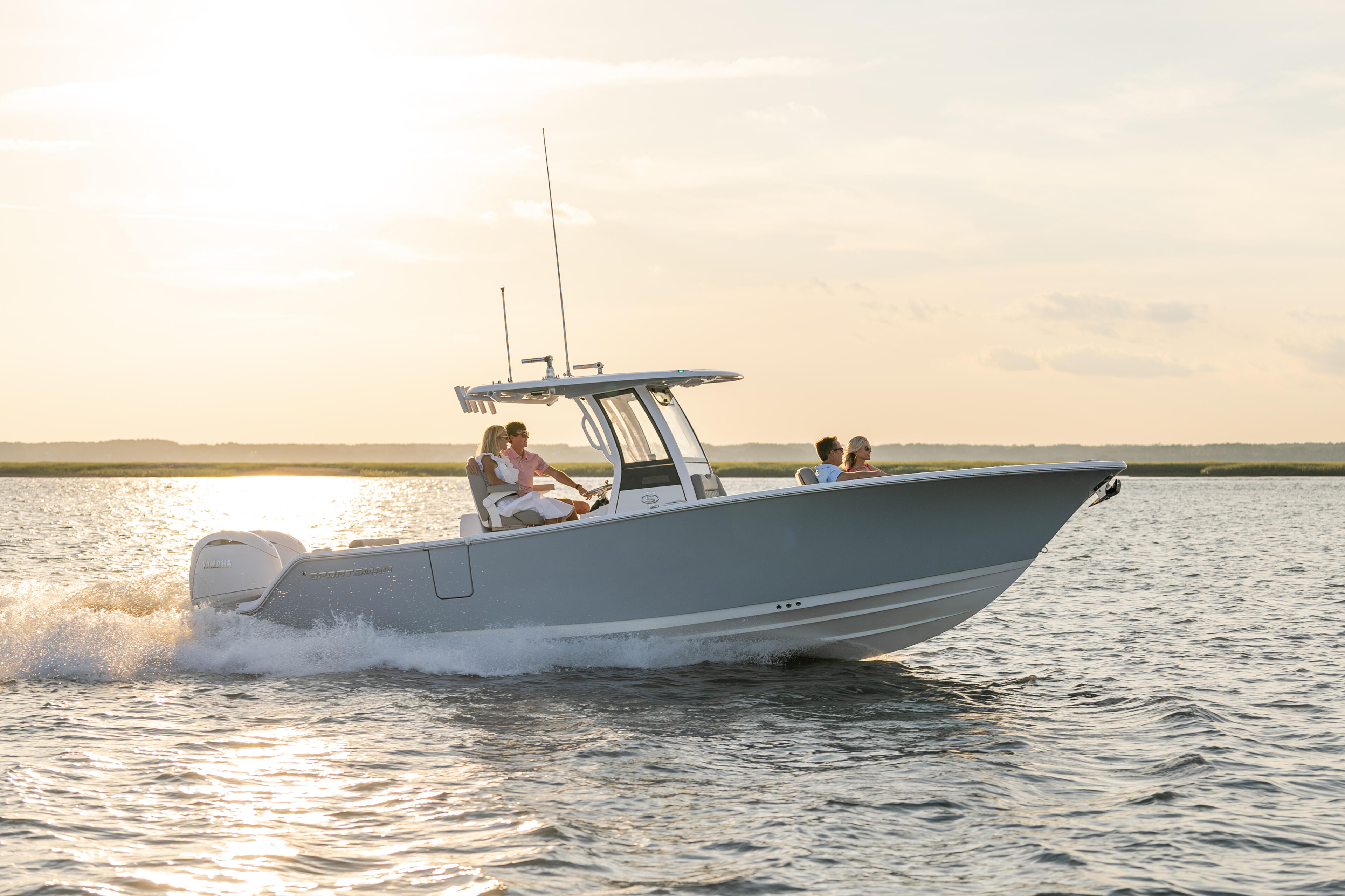 Family cruising in a center console boat through shallow coastal waters at golden hour