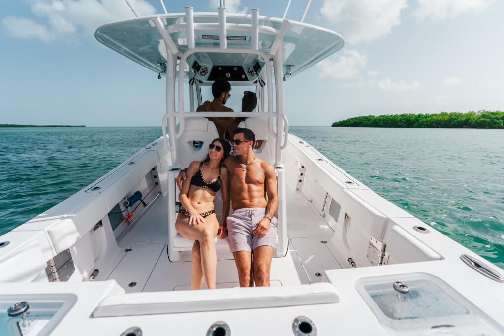 Couple relaxing on center console boat in clear turquoise waters near mangroves