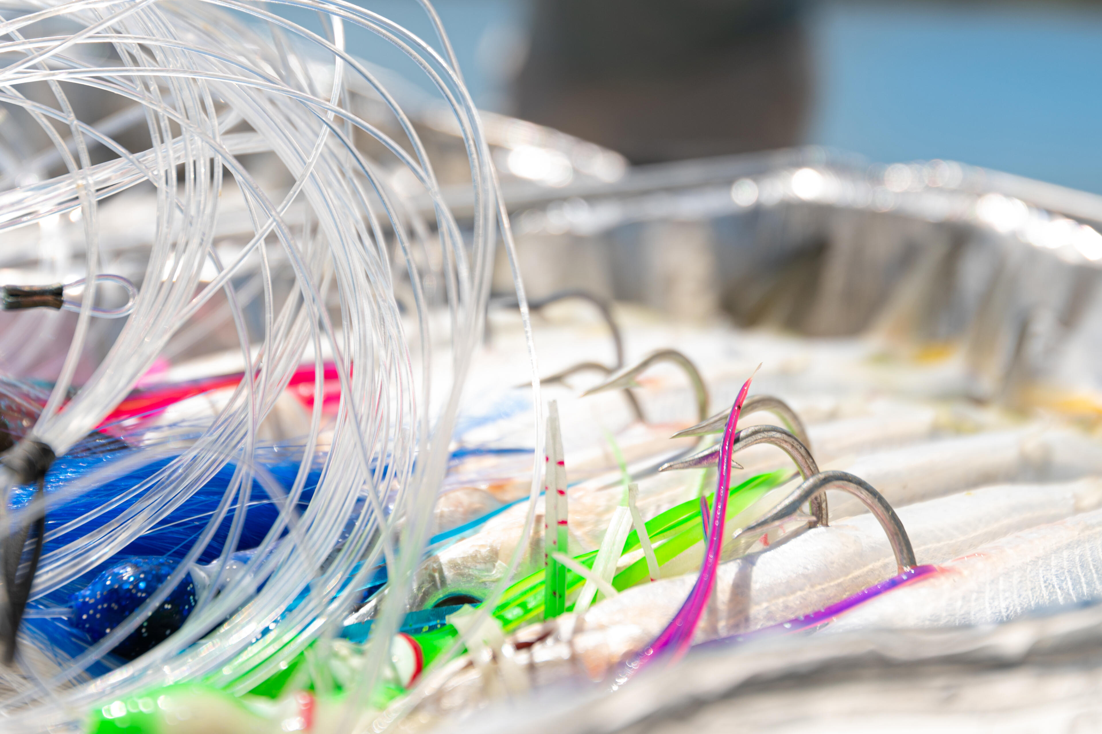 Colorful fishing lures with bright synthetic skirts and hooks arranged in a tackle box