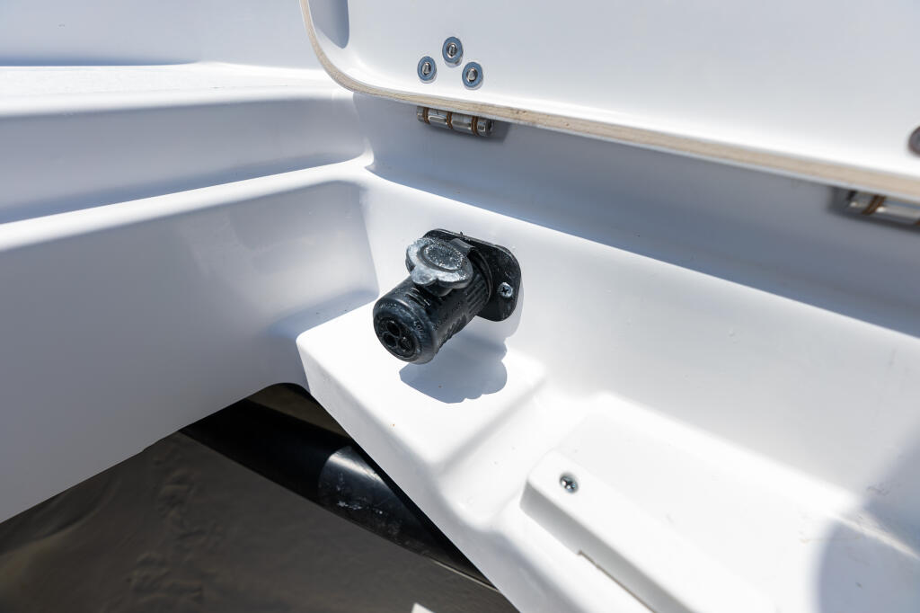 Trolling motor plug connector mounted in white starboard livewell of center console fishing boat