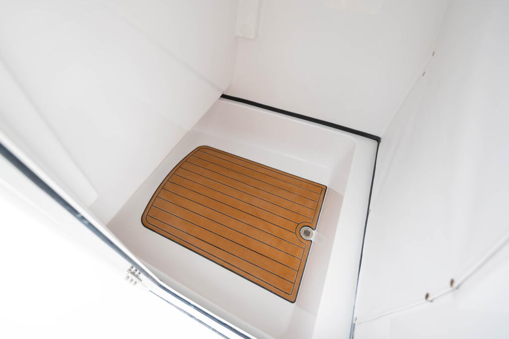 Teak wood flooring in a bright white boat cabin with curved walls