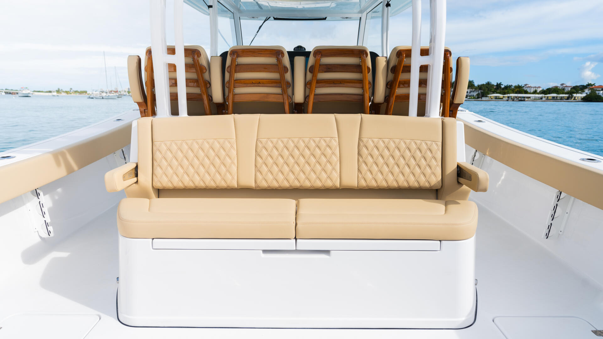 Cream-colored quilted seating with wooden accents in the spacious cockpit of a center console boat