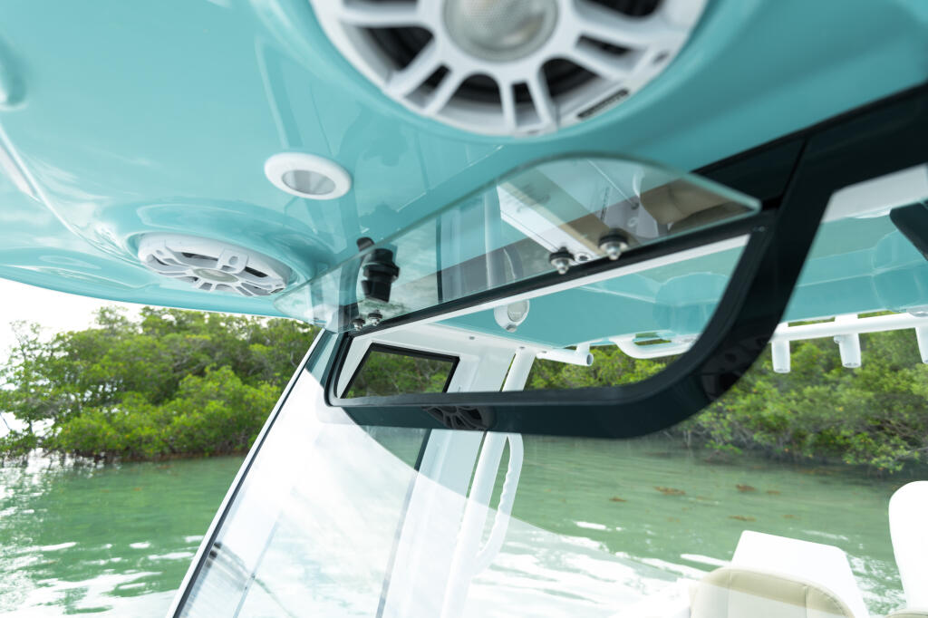 Turquoise hardtop with integrated tempered glass windshield and manual vent viewed from inside the boat