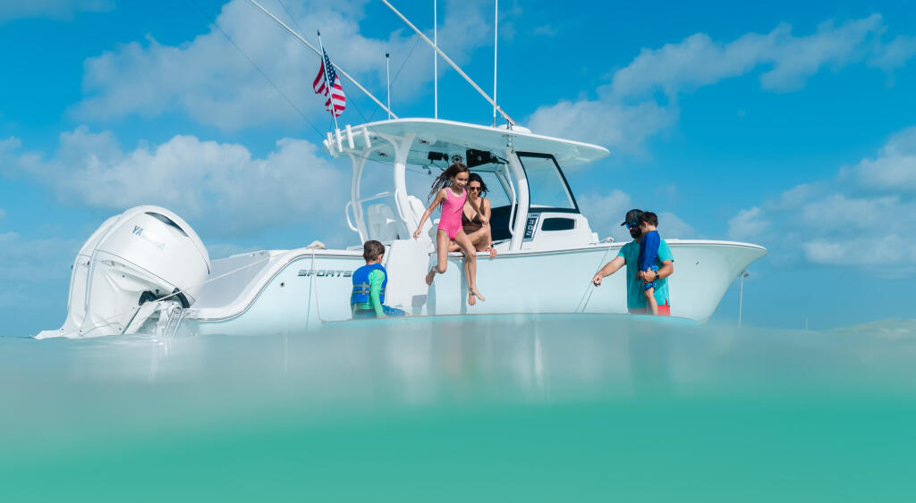Family with children enjoying a white sport boat in shallow turquoise water at a sandbar