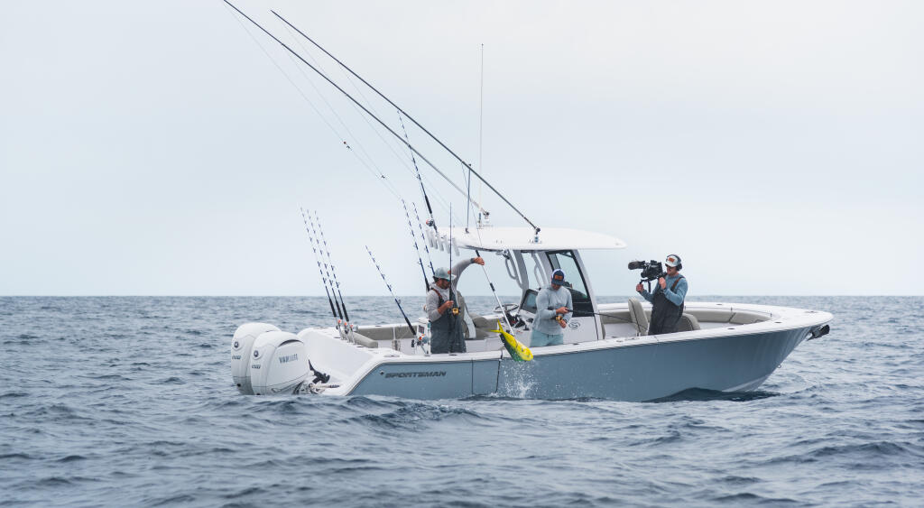 Center console fishing boat with anglers and camera crew on offshore waters