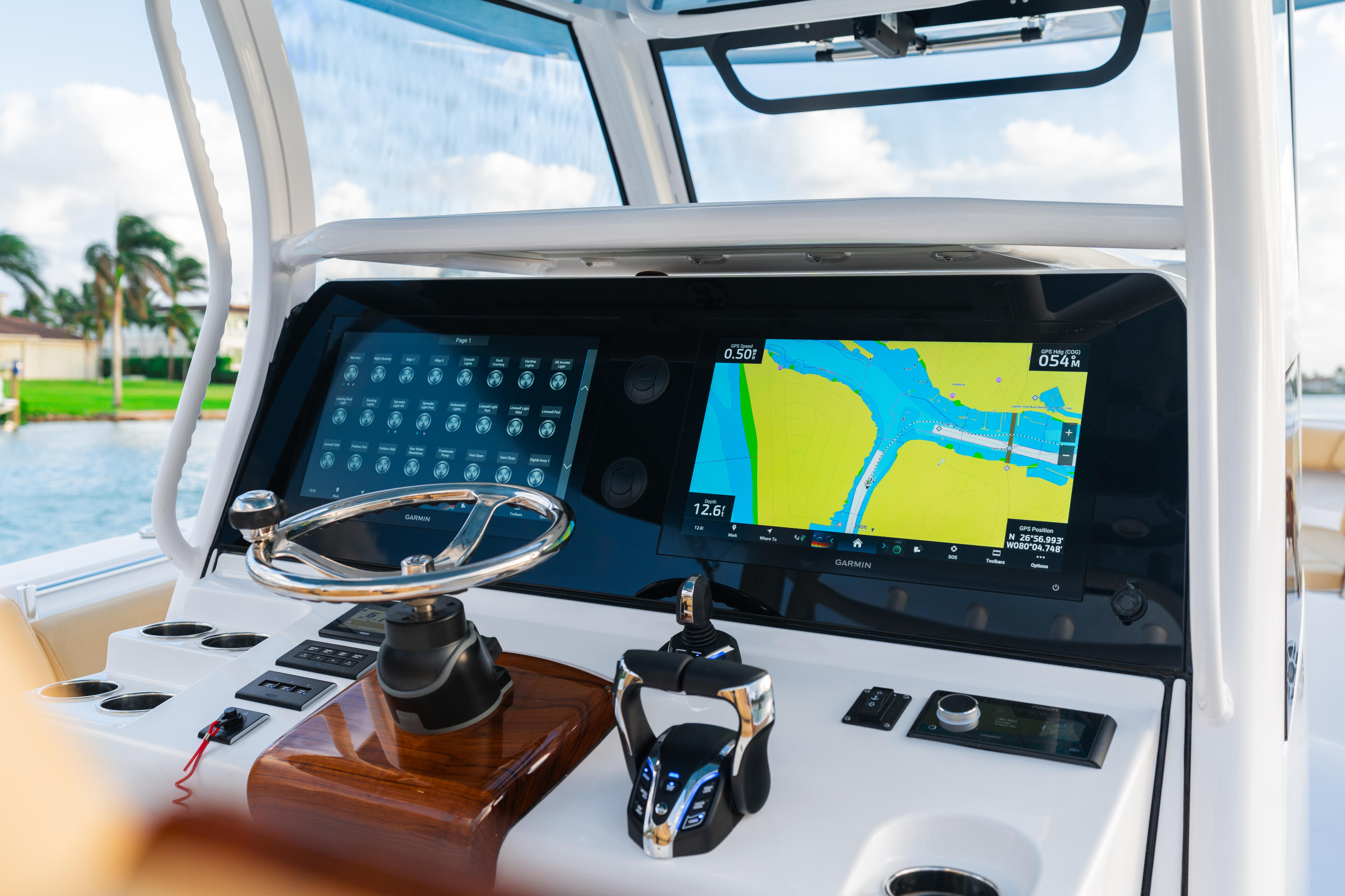 Helm station with Garmin electronics displaying navigational map and control panel with steering wheel