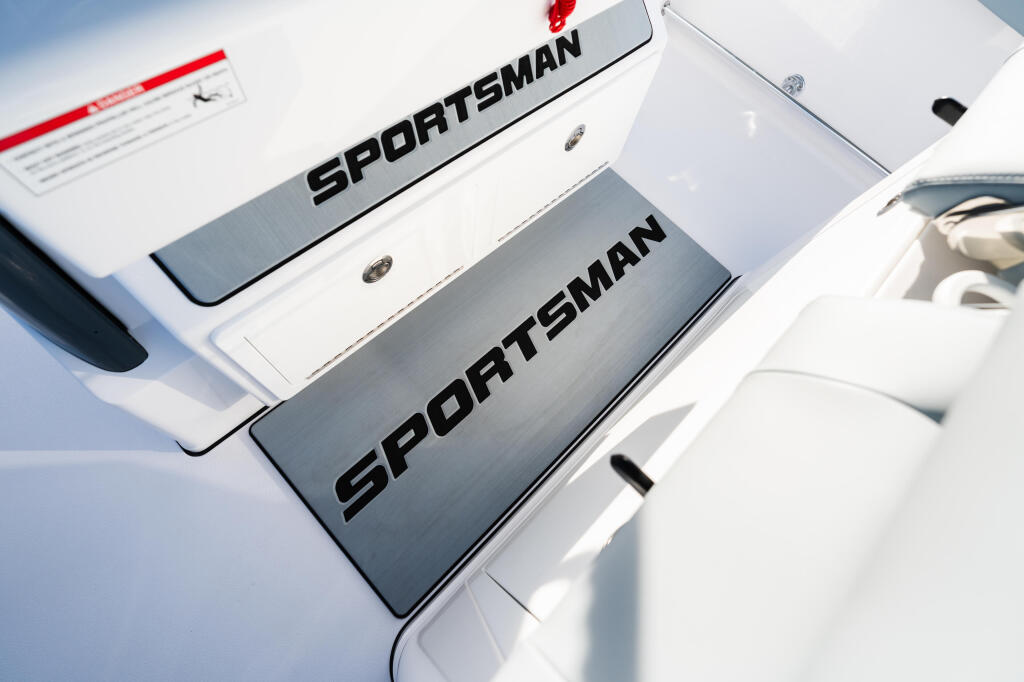 Close-up of Sportsman branding on white boat hull showing model designation