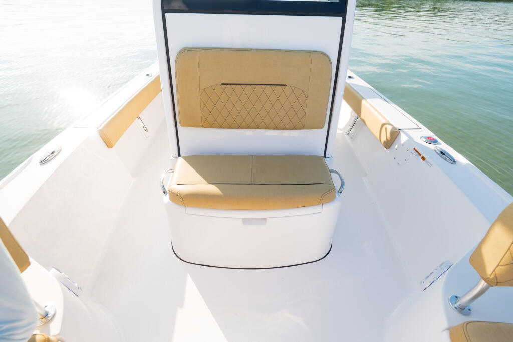 Open console boat with tan and white seating, viewed from above on calm water