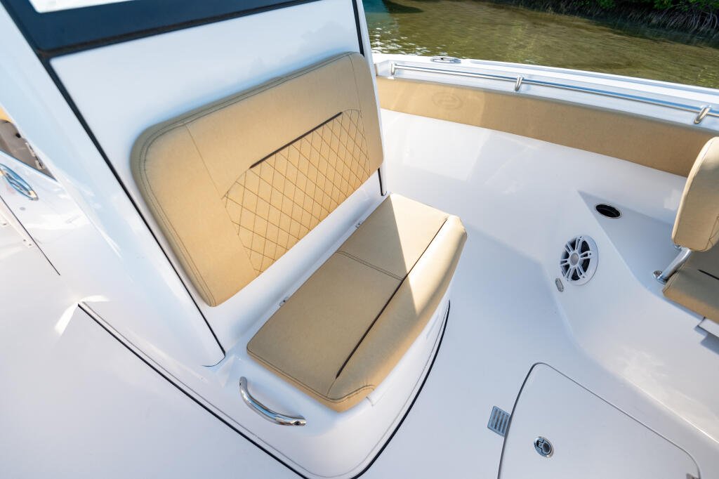 Tan and white upholstered seating with quilted backrest inside center console boat cabin