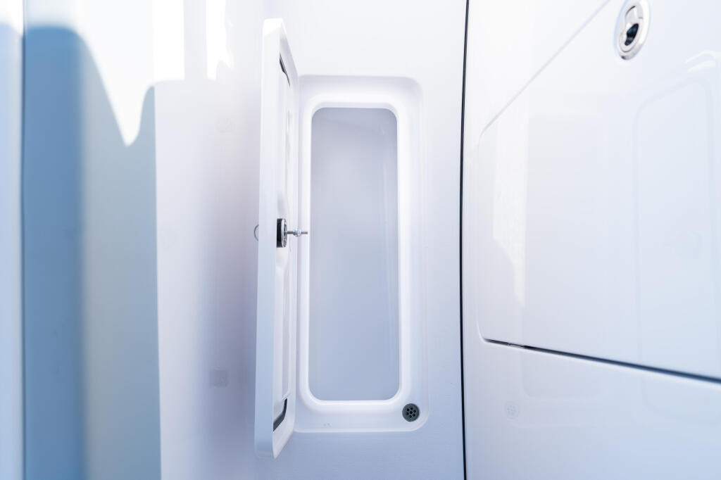 Open cabin door with rectangular window on white boat hull
