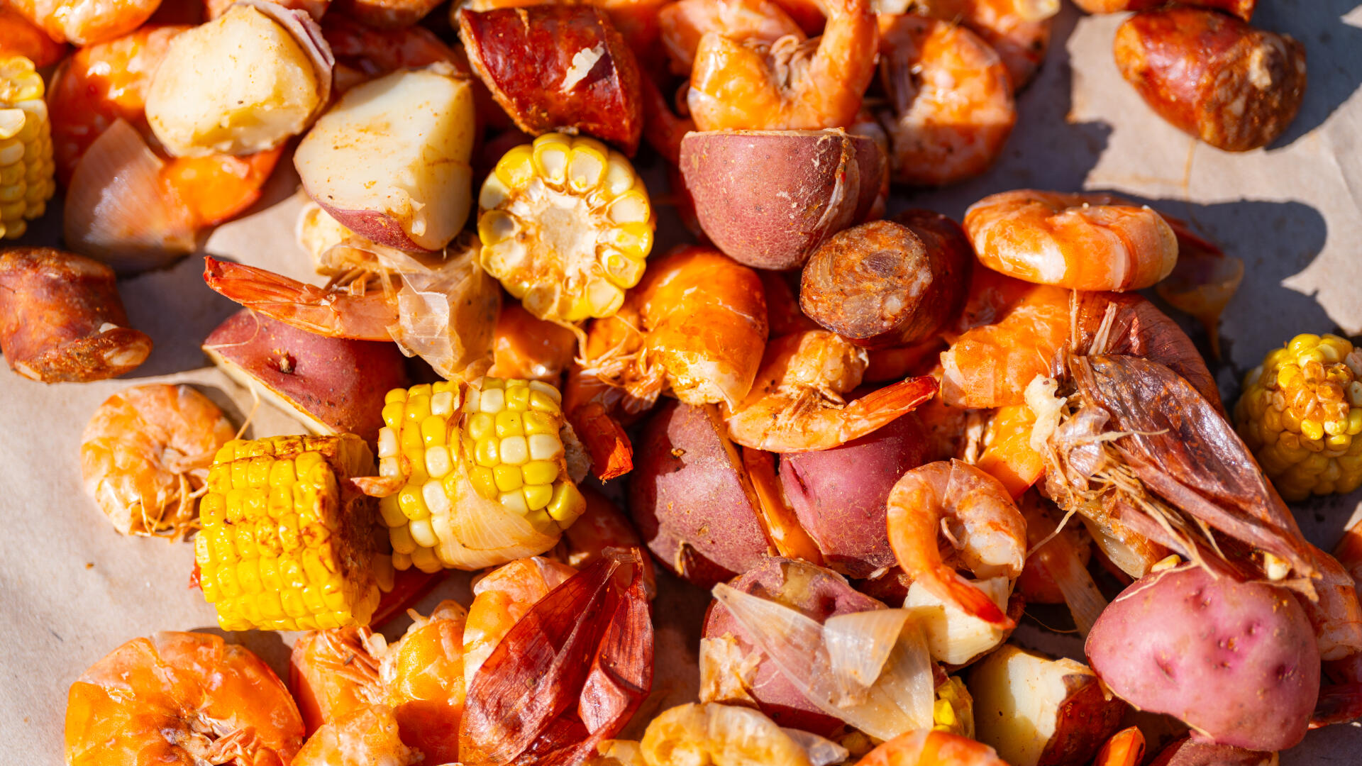 Cooked Lowcountry boil with shrimp, corn, sausage, and potatoes on parchment paper