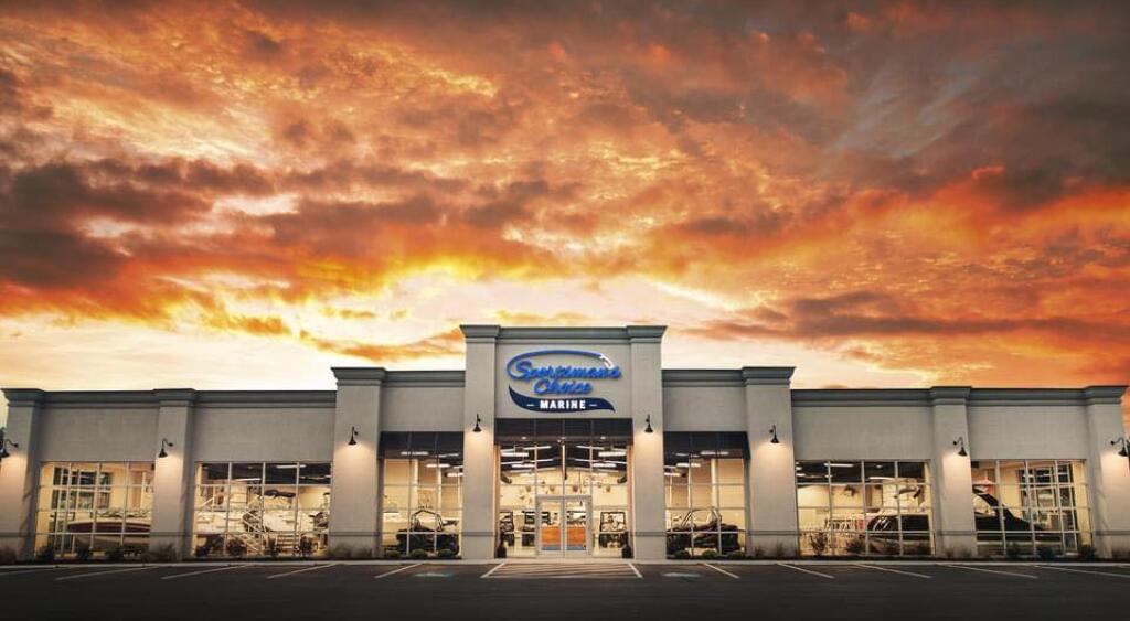 Sportsman's Choice Marine dealership storefront illuminated at dramatic sunset with golden sky