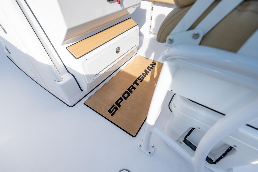 Sportsman center console boat with wood-grained footrest pad and white gel-coat hull detail