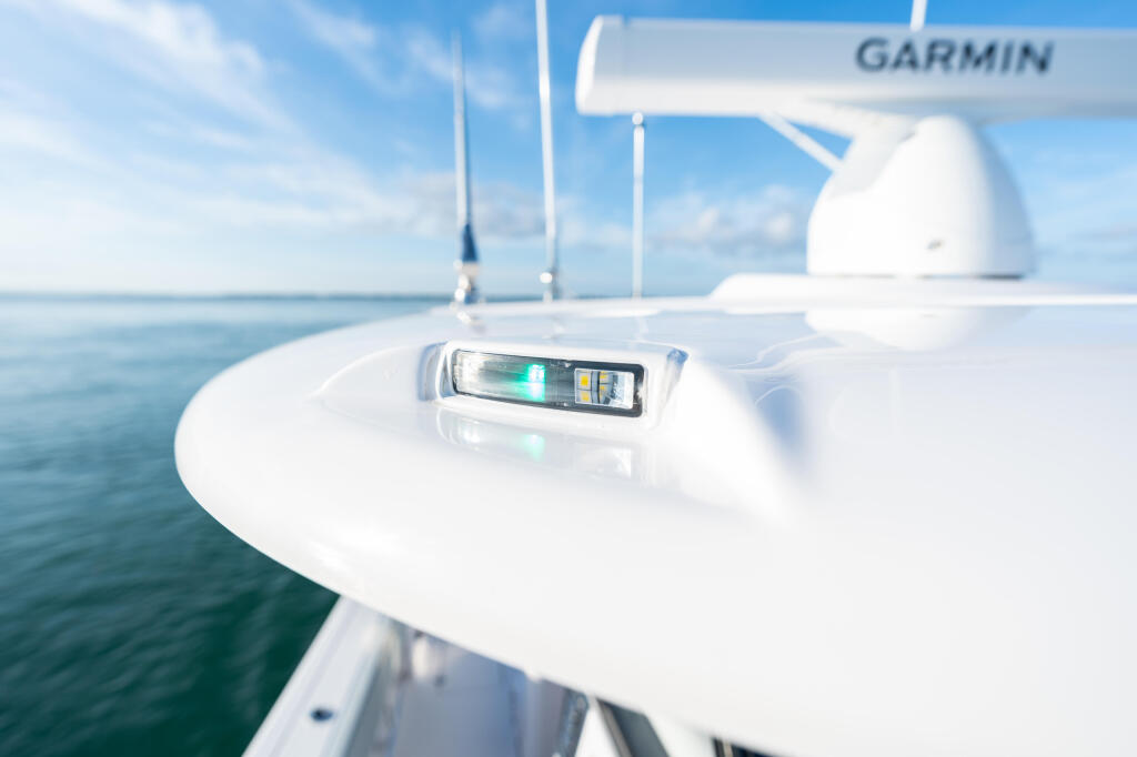 Garmin fish finder display mounted on boat console with radar antenna visible in background