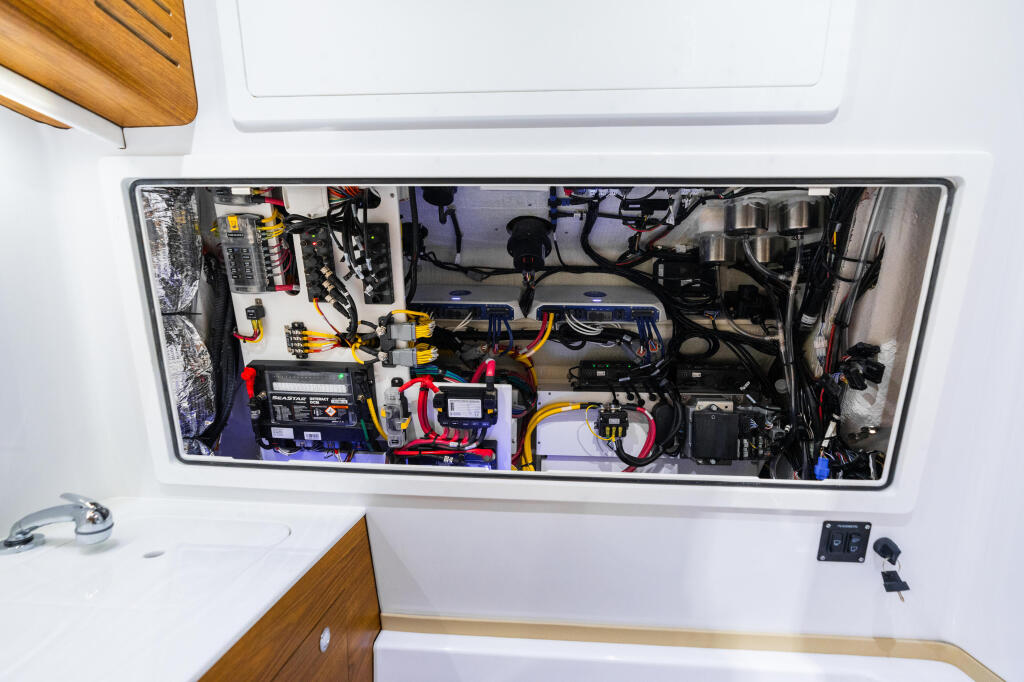 Overhead view of a boat's electrical panel with wiring, breakers, batteries, and marine electronics installed