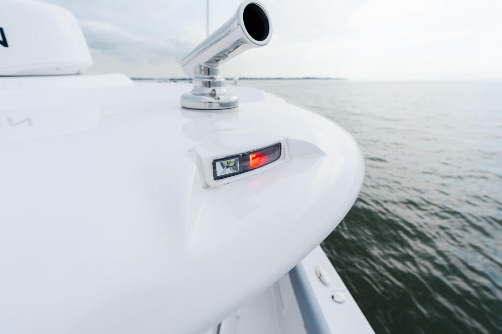 Boat rail and navigation light with calm offshore waters in background