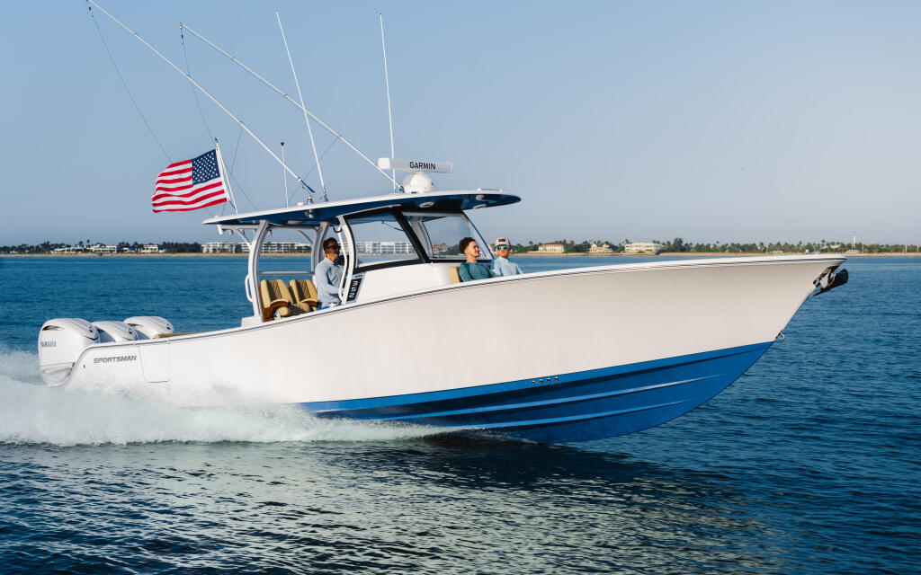 White and blue sportsman boat running through coastal waters with passengers and American flag flying