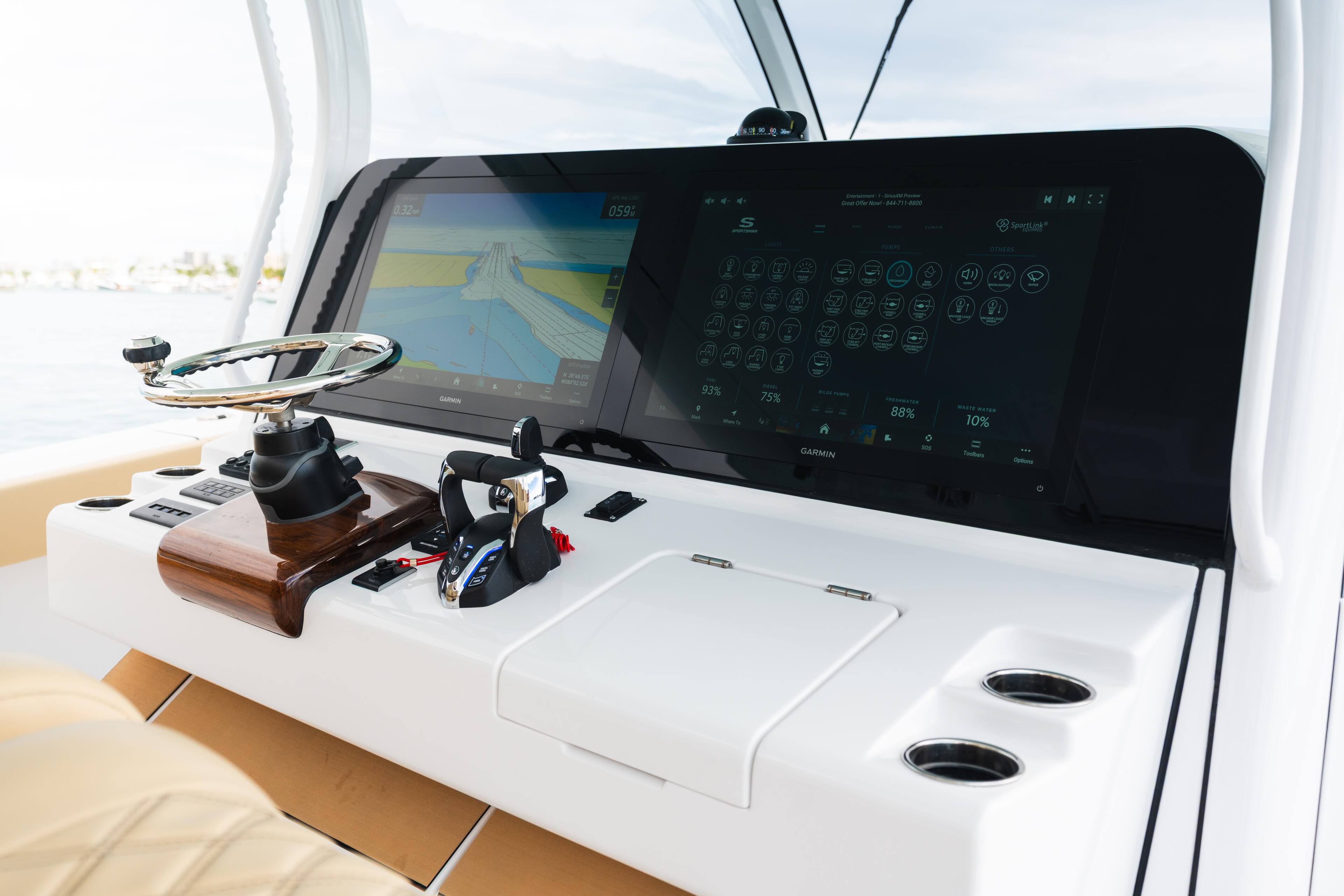 Boat helm with dual Garmin GPSMAP chartplotters displaying navigation data and water conditions