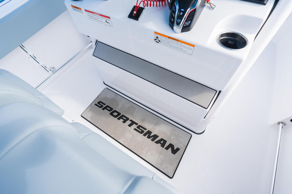 Sportsman branded anti-fatigue mat at the helm station with electronics and storage compartments visible