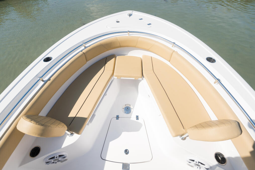 Open 232 center console boat's forward seating area with tan cushions and removable filler board, viewed from above