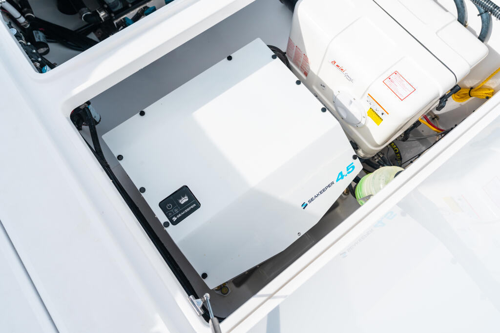 Open boat compartment showing SeaKeeper 4.5 marine stabilizer system with control panel and storage