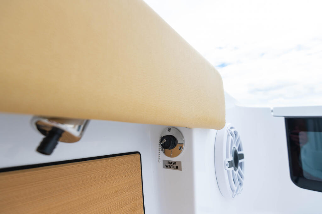 Raw water washdown system valve mounted on the side of a boat hull near the cabin area