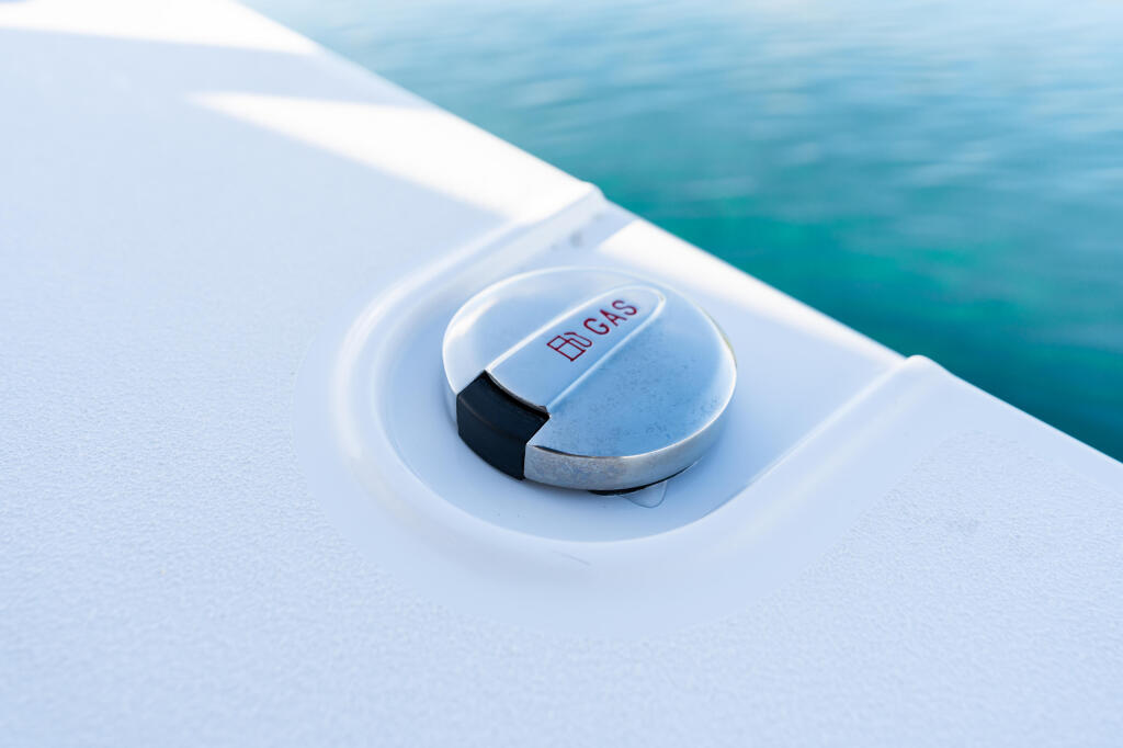 FLDCS fish finder transducer mounted in recessed white fitting on boat hull above turquoise water