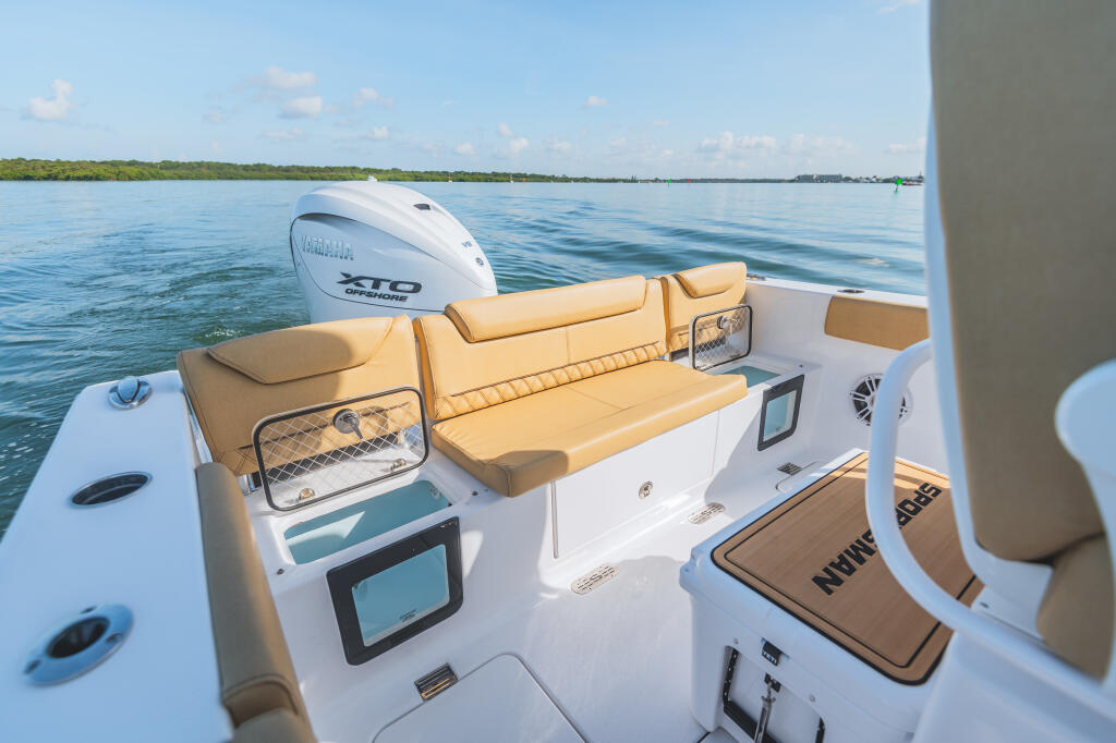 Tan and white center console boat with Yamaha 210 outboard motor on calm water near mangroves