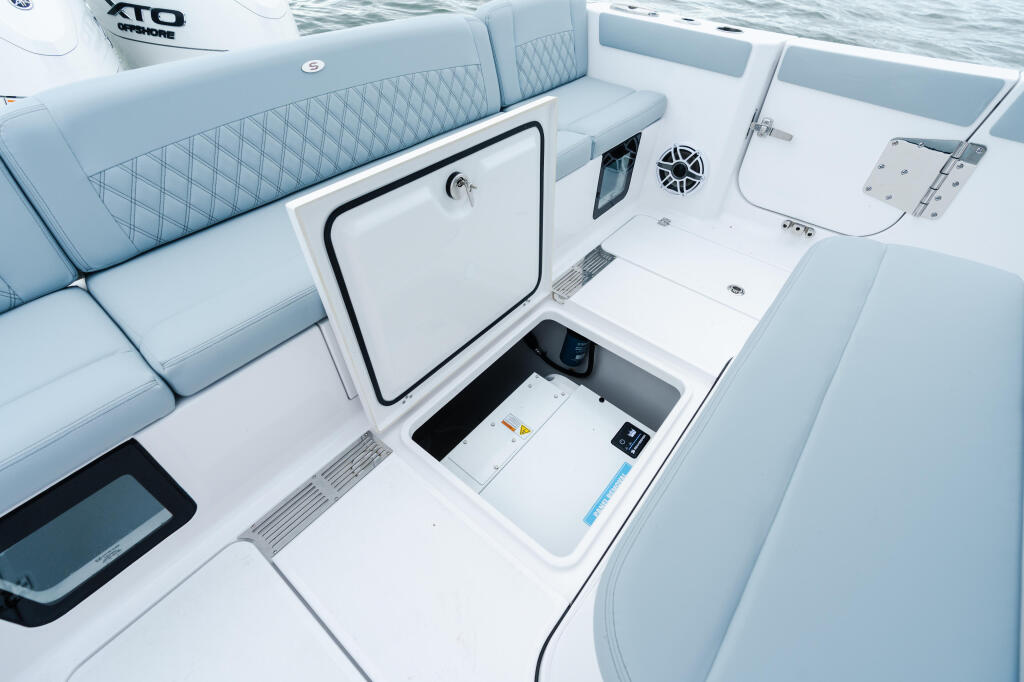Spacious center console with quilted seating, open storage hatch, and integrated electronics display