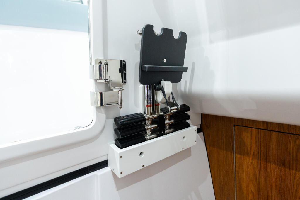Cabin interior showing electronic control panels and storage mounted on white walls with wooden cabinetry