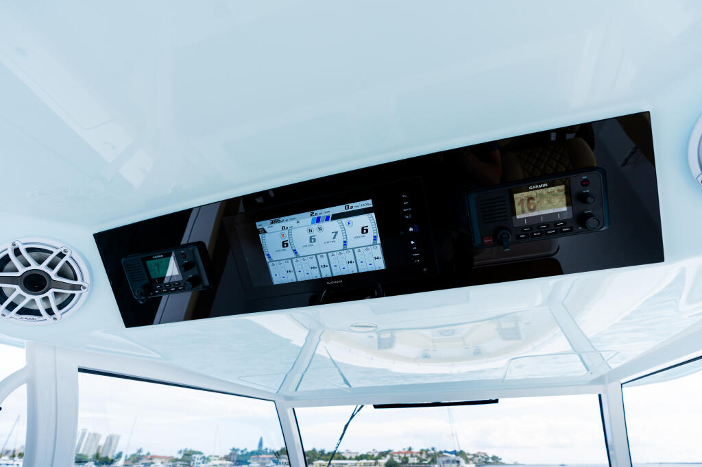 Helm dashboard with multiple electronic displays and navigation equipment mounted under hard-top canopy