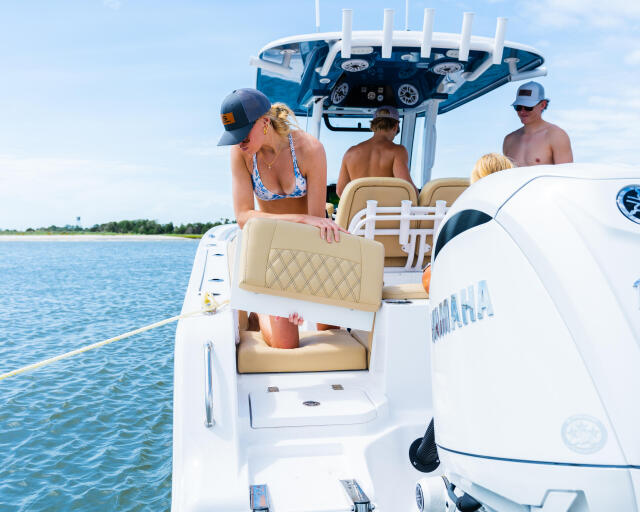 Couple enjoying beverages and relaxation aboard a white center console boat on calm blue water