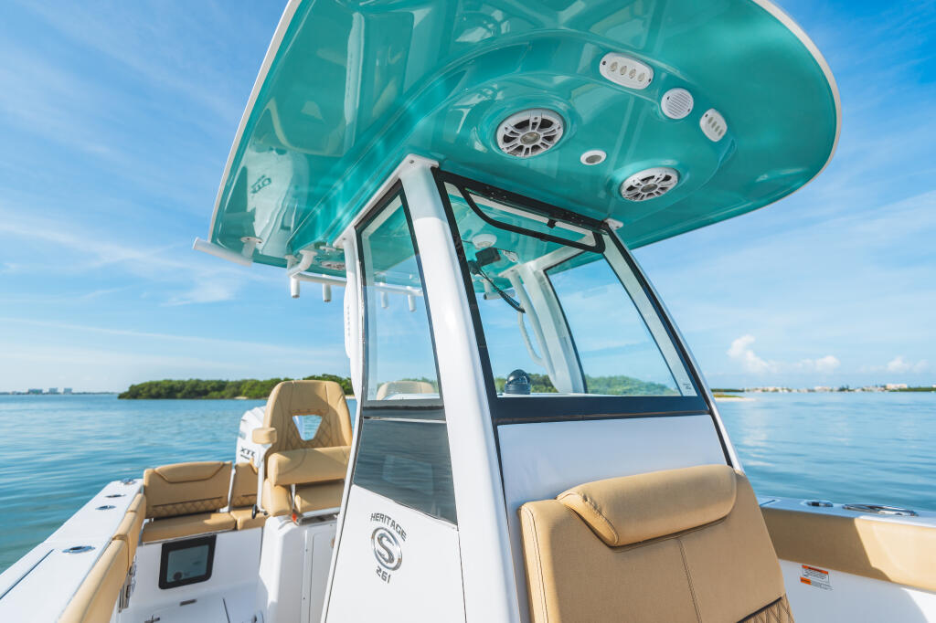 Teal hard-top with integrated windshield and tan seating on Heritage 261 center console boat at anchor