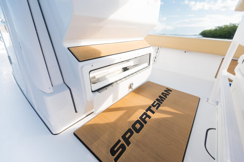 Bright boat deck with tan sunshade, white helm pod, storage compartment, and wooden Sport Smart platform