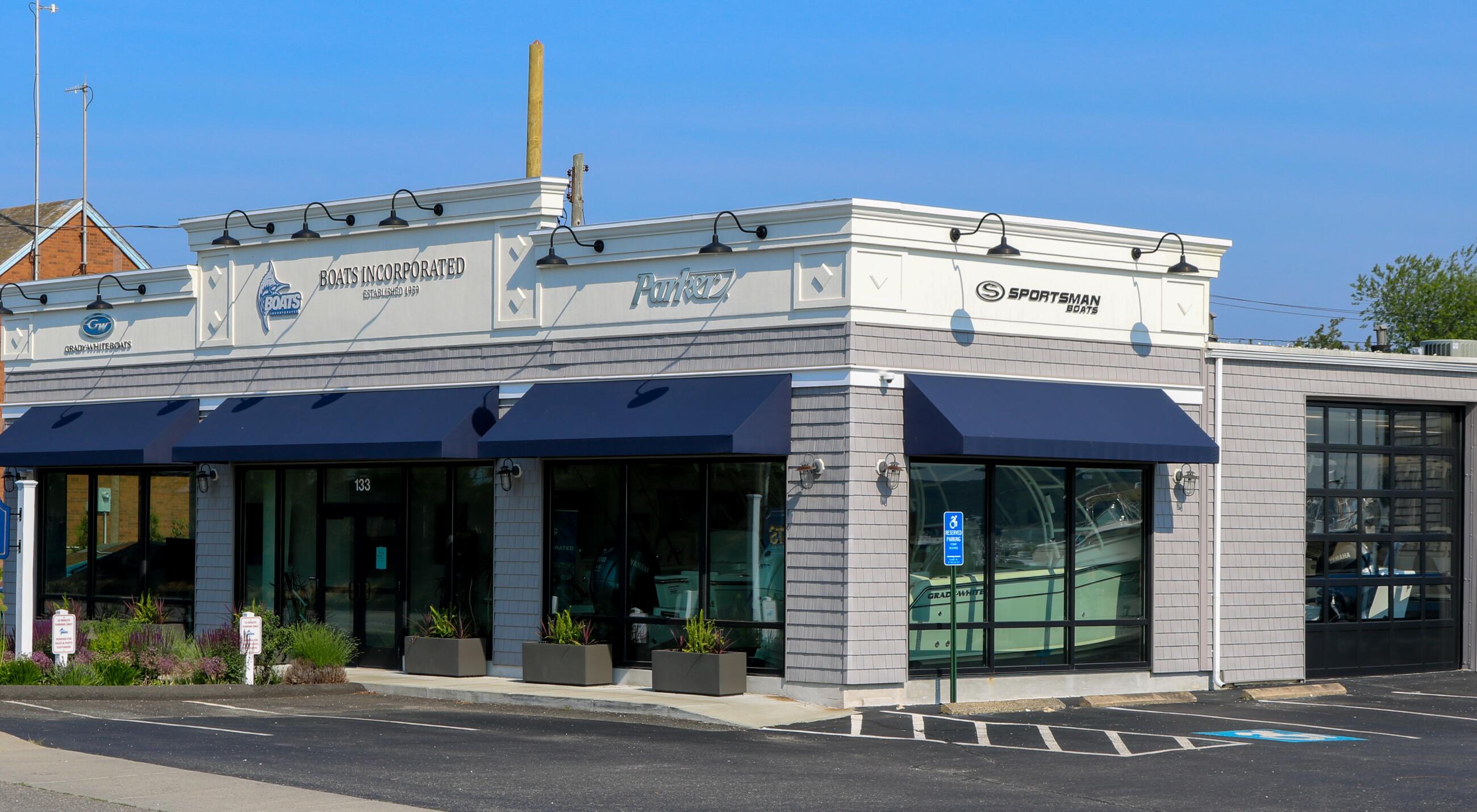 Boats Incorporated and Sportsman marine dealership storefront with blue awnings and large display windows
