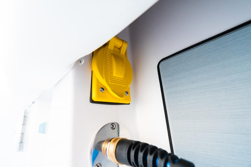 Yellow exterior light fixture and power outlet mounted on boat cabin wall